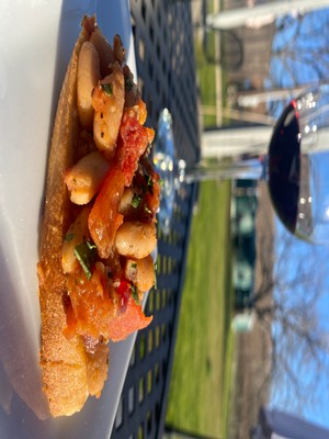 image of rosemary cannellini bean bruschetta next to a glass of wine