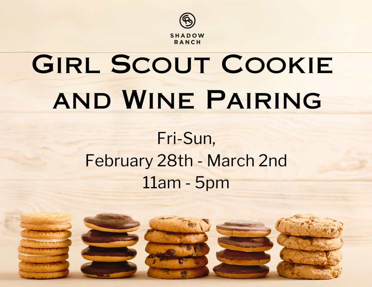 Light wood background, stacks of cookies in the foreground. Text reads Girl Scout Cookie and Wine Pairing. Fri-Sun February 28th-March 2nd. 11am-5pm